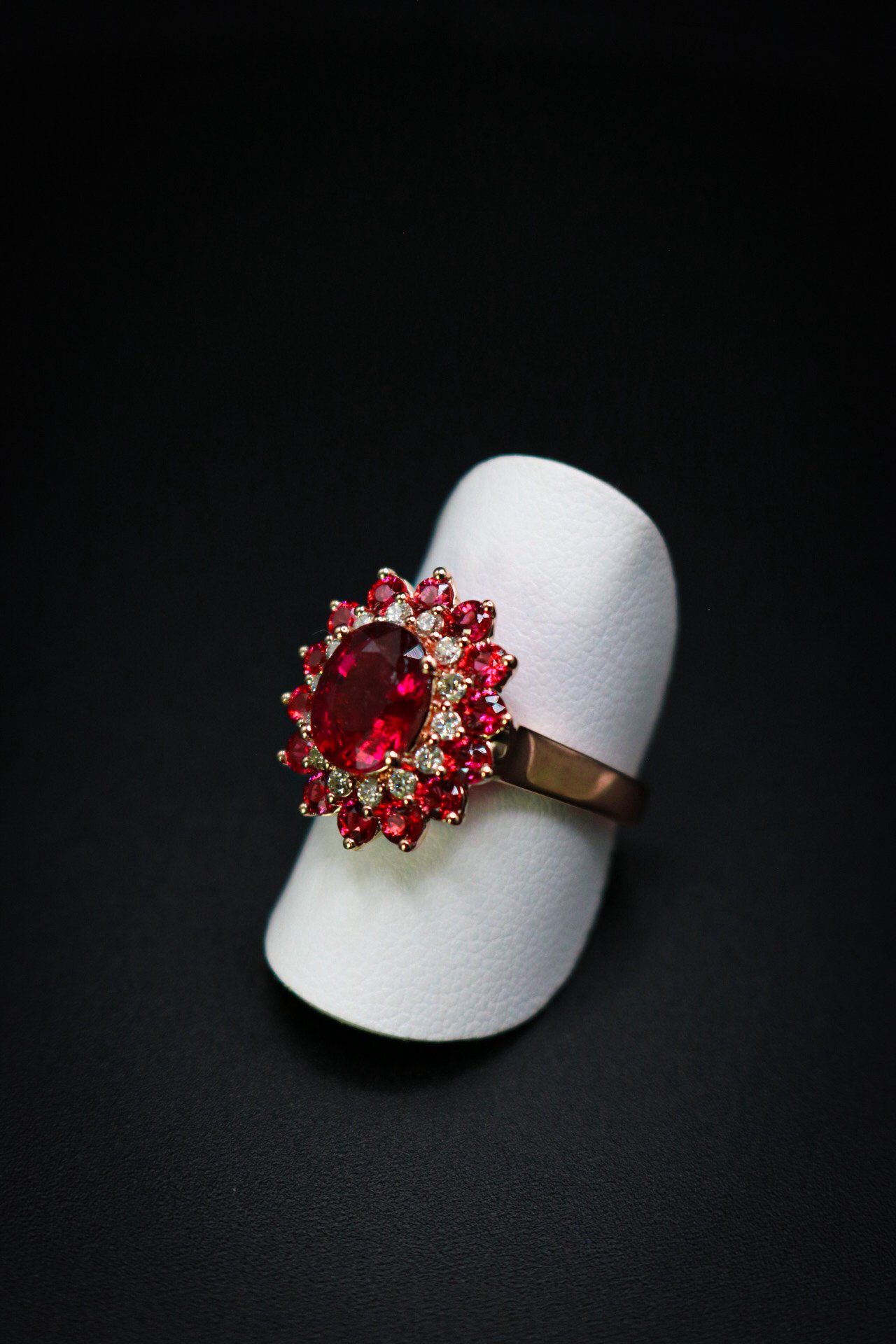 Pink tourmaline ring with double halo of pink spinel and natural diamonds in gold, studio photograph